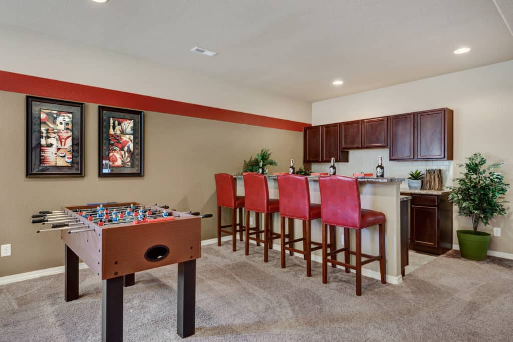 a photo of a basement with bright red accents and a foosball table