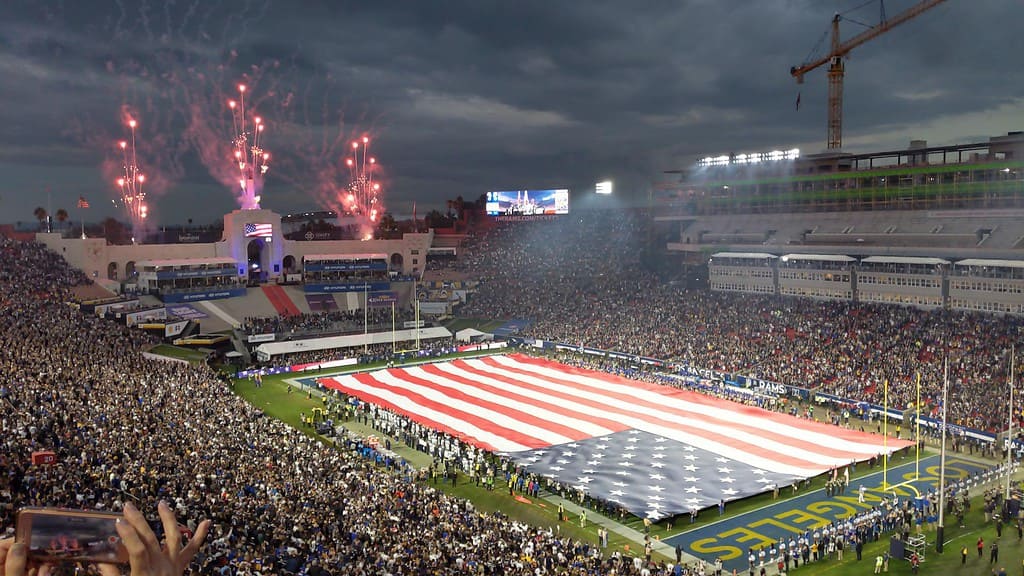 a photo of the LA Coliseum with an american flag and fireworks